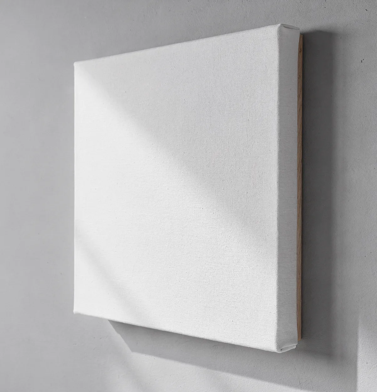 Blank white gallery-wrapped canvas on a wall, shot at a three-quarter angle in a minimal studio, a SudoMock PSD template for canvas print listing images