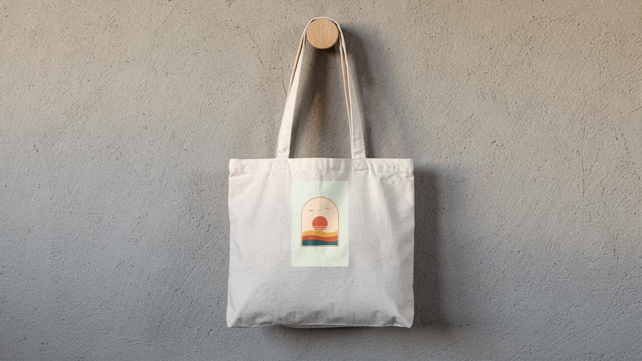Canvas tote mockup rendered from a product photo with a pastel arch sunset print on the front panel