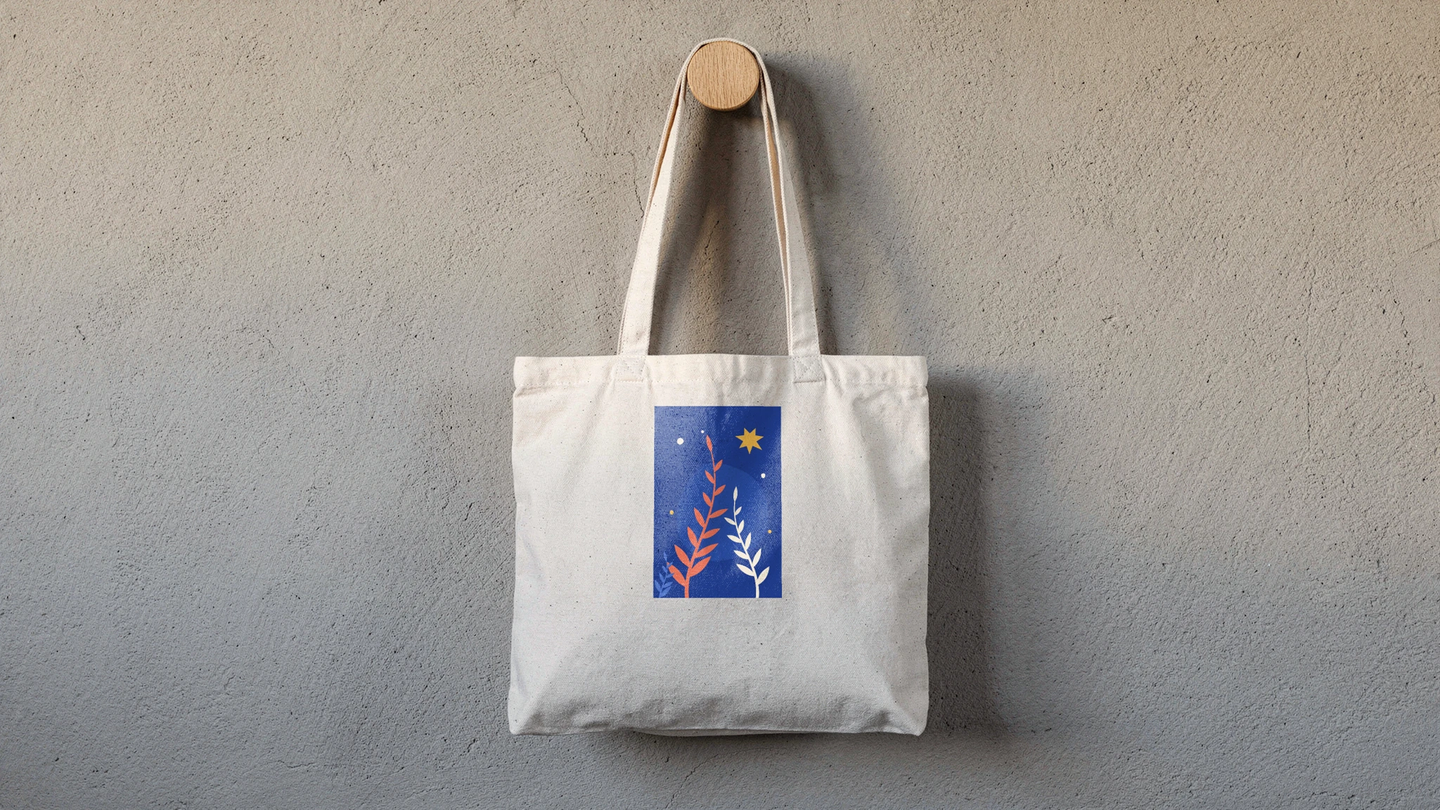 Canvas tote mockup rendered from a product photo with a tall blue botanical print on the front panel